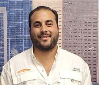male employee with buildings in the background